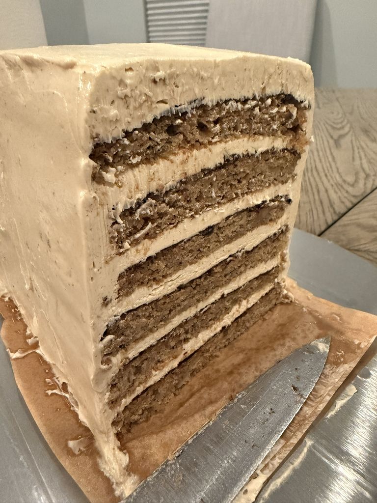 Cross-section of the finished cake showing six banana bars, buttercream, and thin ganache lines