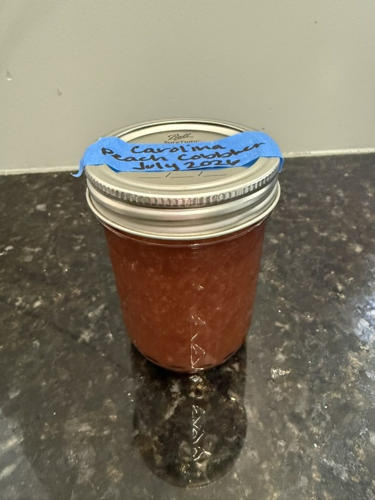 A labeled jar of Carolina Peach Cobbler jelly
