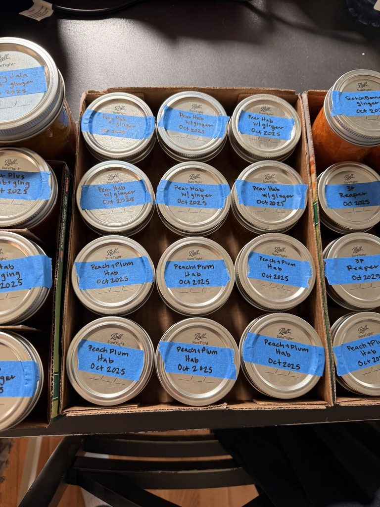 Boxes of jars labeled Pear Hab w/ ginger and Peach+Plum Hab