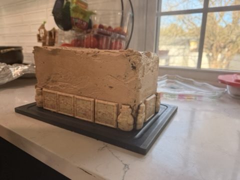 The frosted cake from an angle, cookie border along the base