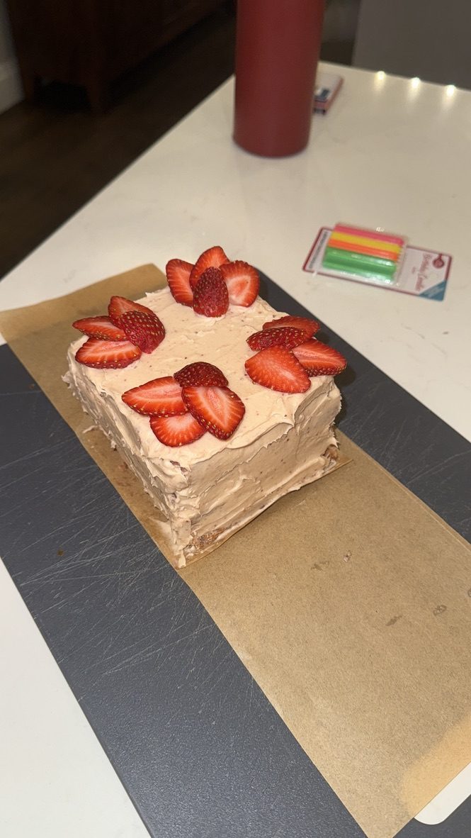 The finished cake topped with fanned strawberry slices