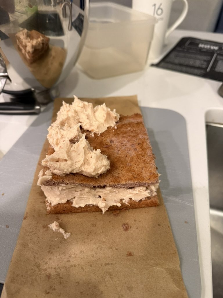 A cake layer spread with strawberry buttercream