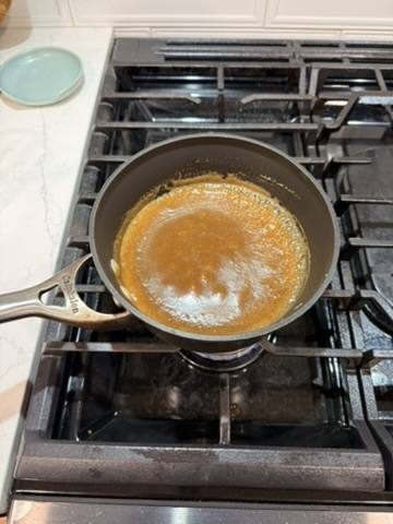 The sticky toffee sauce coming together on the stove