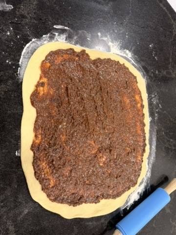 The dough rolled out with the date filling spread across it
